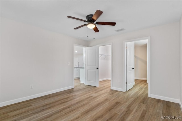 6658 N Bedstrow Blvd, Dunnellon, FL 34434 - unfurnished bedroom with light wood finished floors, a walk in closet, and a ceiling fan