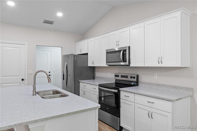 6658 N Bedstrow Blvd, Dunnellon, FL 34434 - kitchen with appliances with stainless steel finishes, vaulted ceiling, white cabinetry, and recessed lighting