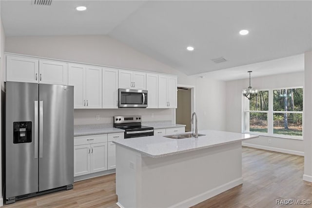 6658 N Bedstrow Blvd, Dunnellon, FL 34434 - kitchen featuring appliances with stainless steel finishes, lofted ceiling, light wood-type flooring, a chandelier, and white cabinets