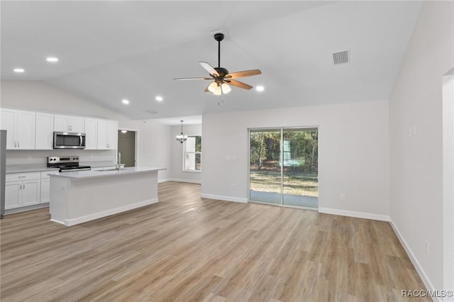 6658 N Bedstrow Blvd, Dunnellon, FL 34434 - kitchen with stainless steel microwave, range with electric cooktop, lofted ceiling, open floor plan, and light wood-type flooring