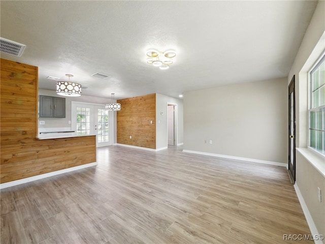 34 S Harrison St, Beverly Hills, FL 34465 - unfurnished living room with baseboards, light wood-style floors, wooden walls, and a textured ceiling