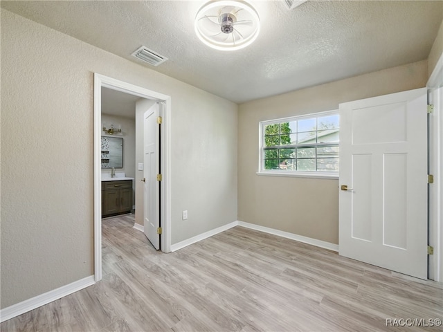 34 S Harrison St, Beverly Hills, FL 34465 - unfurnished bedroom featuring a textured ceiling, light wood-style flooring, and baseboards