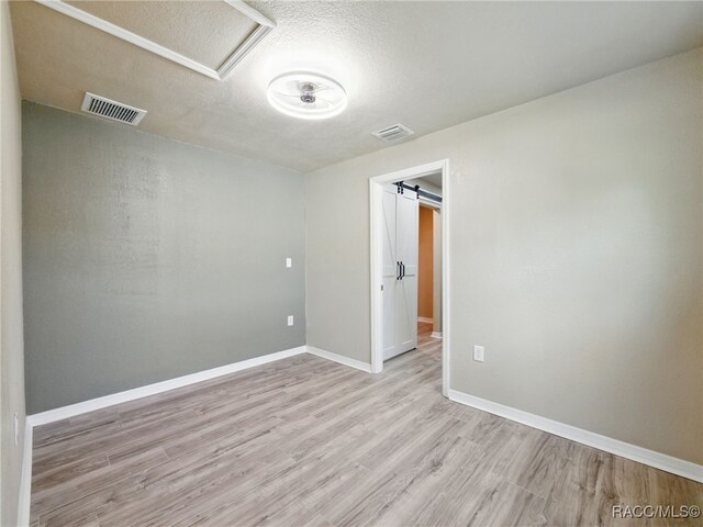 34 S Harrison St, Beverly Hills, FL 34465 - spare room with wood finished floors, baseboards, a textured ceiling, and attic access