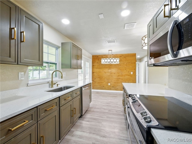 34 S Harrison St, Beverly Hills, FL 34465 - kitchen with stainless steel appliances, a sink, light wood-type flooring, wooden walls, and baseboards
