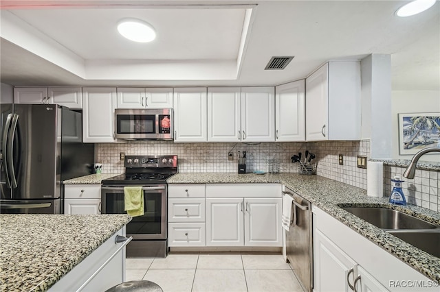 kitchen featuring white cabinets, appliances with stainless steel finishes, tasteful backsplash, and sink