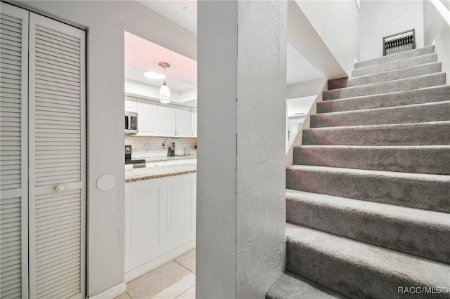 stairs featuring tile patterned floors