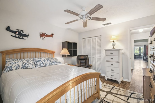 bedroom featuring ceiling fan, dark hardwood / wood-style flooring, and a closet