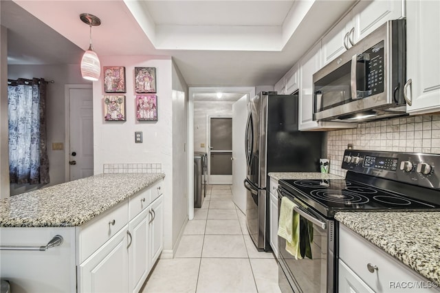 kitchen with tasteful backsplash, stainless steel appliances, a raised ceiling, pendant lighting, and white cabinets