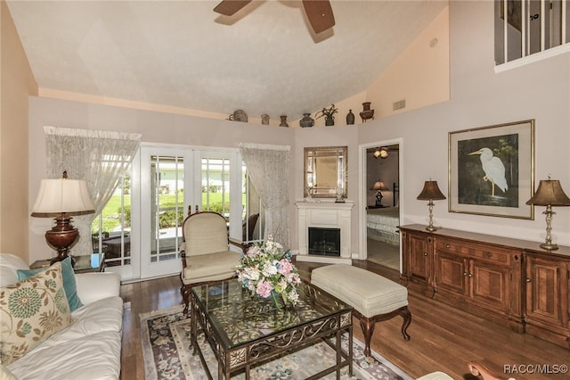 living room with dark hardwood / wood-style flooring, ceiling fan, french doors, and high vaulted ceiling