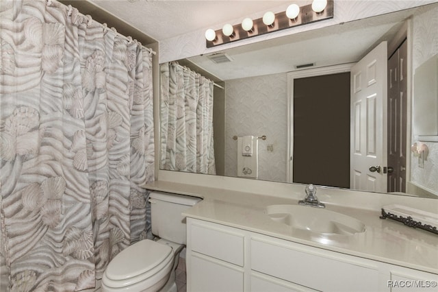 bathroom featuring vanity, a textured ceiling, and toilet