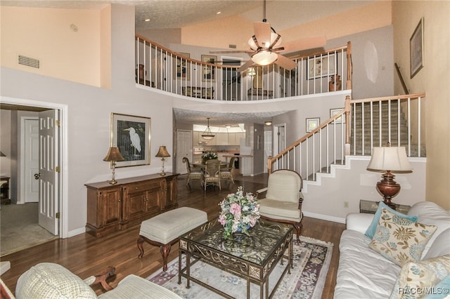 living room with ceiling fan, dark hardwood / wood-style flooring, and high vaulted ceiling