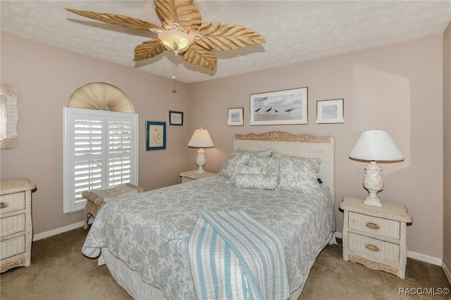 bedroom featuring a textured ceiling, light colored carpet, and ceiling fan