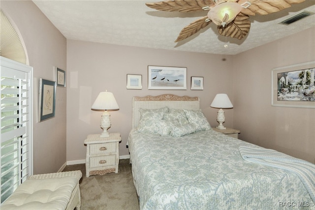 bedroom featuring a textured ceiling, ceiling fan, and light carpet