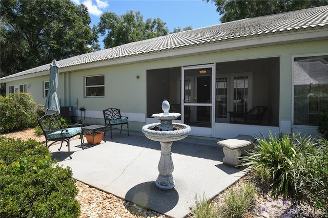 rear view of house featuring a patio, central AC, and a sunroom