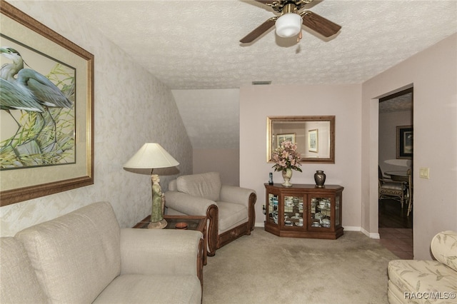 living area with ceiling fan, light colored carpet, a textured ceiling, and vaulted ceiling