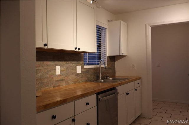 kitchen featuring dishwasher, sink, butcher block countertops, backsplash, and white cabinets