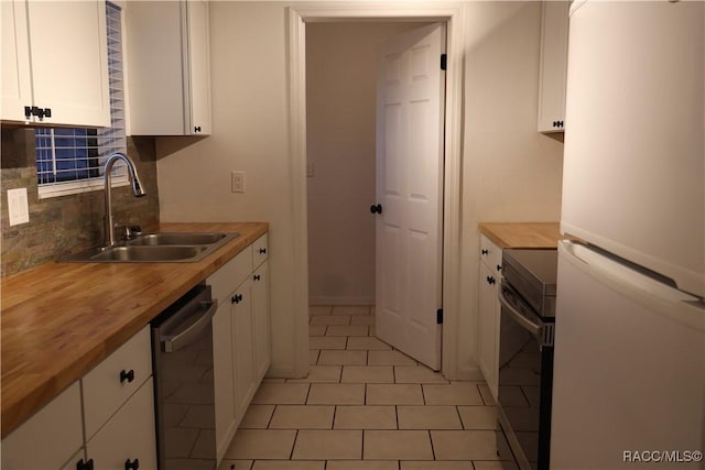 kitchen featuring wooden counters, appliances with stainless steel finishes, backsplash, sink, and white cabinets