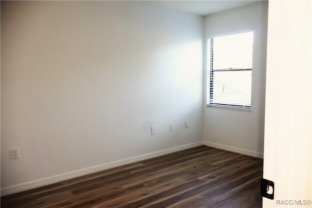 unfurnished room featuring dark wood-type flooring