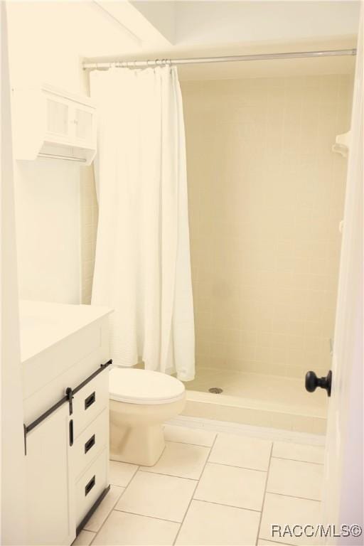 bathroom featuring tile patterned floors, vanity, a shower with shower curtain, and toilet