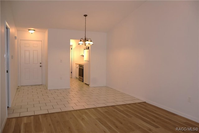 tiled empty room featuring a chandelier