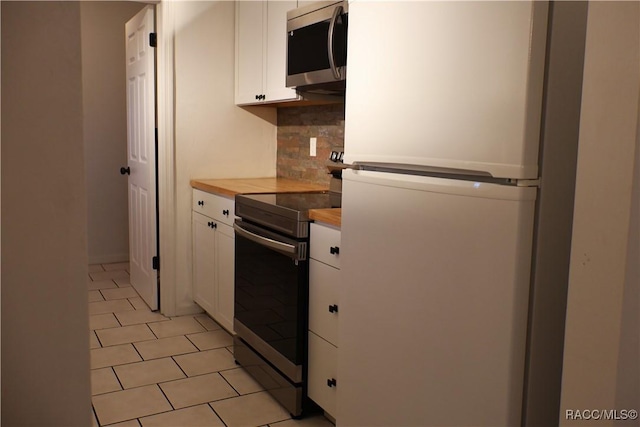 kitchen featuring decorative backsplash, stainless steel appliances, white cabinetry, and butcher block counters