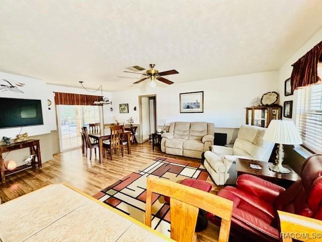 living area featuring wood finished floors and ceiling fan