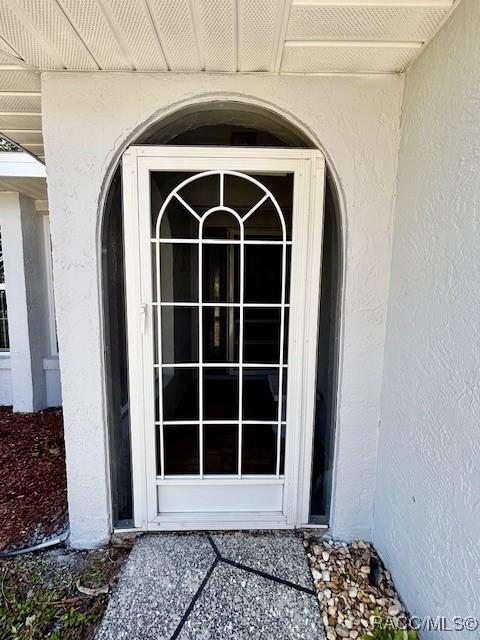 entrance to property featuring stucco siding