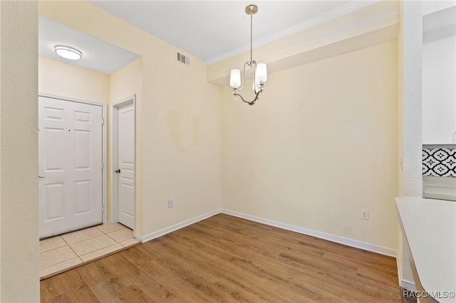17108 Carrington Park Dr Unit 711, Tampa, FL 33647 - unfurnished dining area featuring a notable chandelier, visible vents, baseboards, and wood finished floors