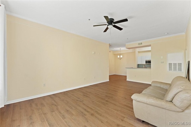 17108 Carrington Park Dr Unit 711, Tampa, FL 33647 - living area featuring light wood-style floors, ceiling fan with notable chandelier, and ornamental molding