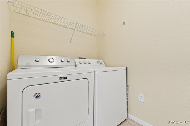 17108 Carrington Park Dr Unit 711, Tampa, FL 33647 - washroom with washing machine and clothes dryer, light tile patterned flooring, laundry area, and baseboards