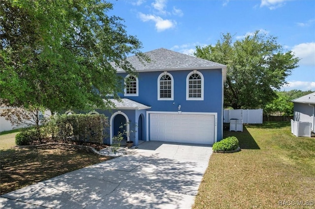 traditional home with stucco siding, fence, a front lawn, concrete driveway, and an attached garage