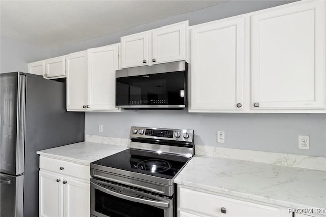 kitchen featuring white cabinets, appliances with stainless steel finishes, and light stone counters