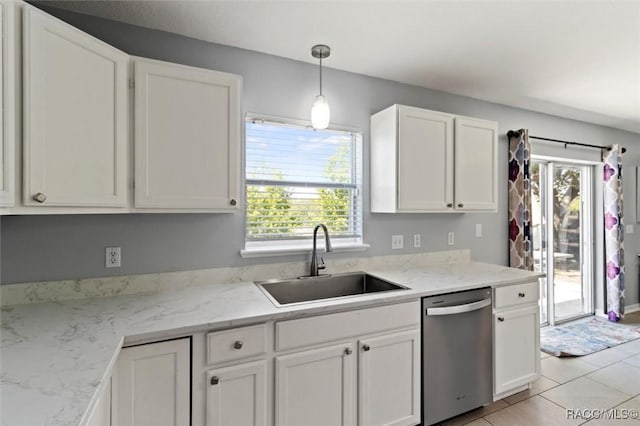 kitchen featuring white cabinetry, stainless steel dishwasher, a sink, light tile patterned flooring, and hanging light fixtures