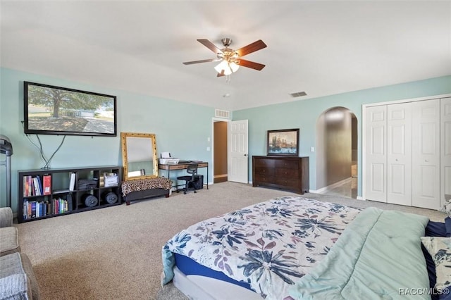 bedroom with arched walkways, visible vents, a closet, and carpet floors