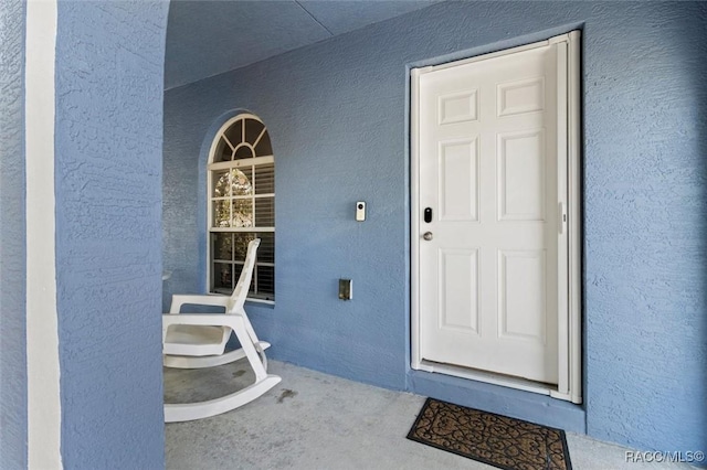 view of exterior entry featuring stucco siding