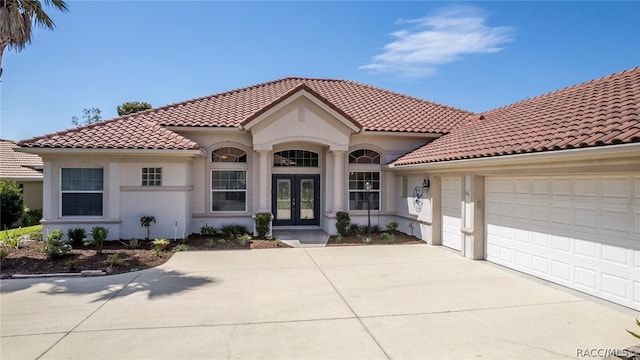 mediterranean / spanish house with french doors and a garage