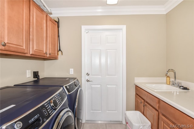 washroom with cabinets, ornamental molding, washer and clothes dryer, sink, and light tile patterned floors