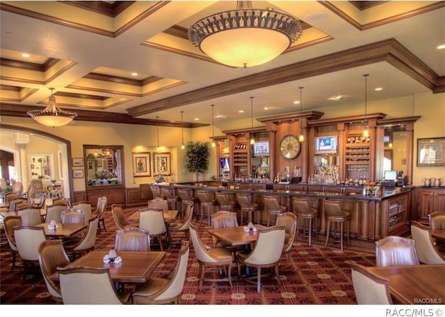 dining area featuring bar area, crown molding, beamed ceiling, and coffered ceiling