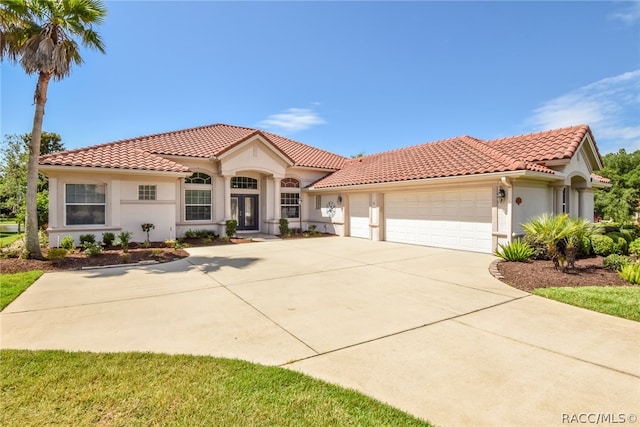 mediterranean / spanish house featuring french doors and a garage