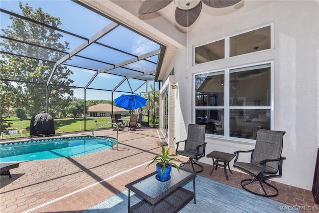 view of swimming pool with a lanai, a patio area, and ceiling fan