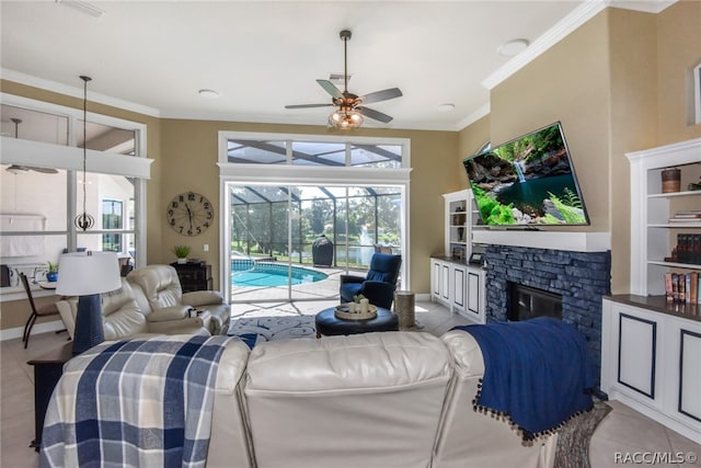 living room featuring light tile patterned floors, a stone fireplace, ceiling fan, and crown molding