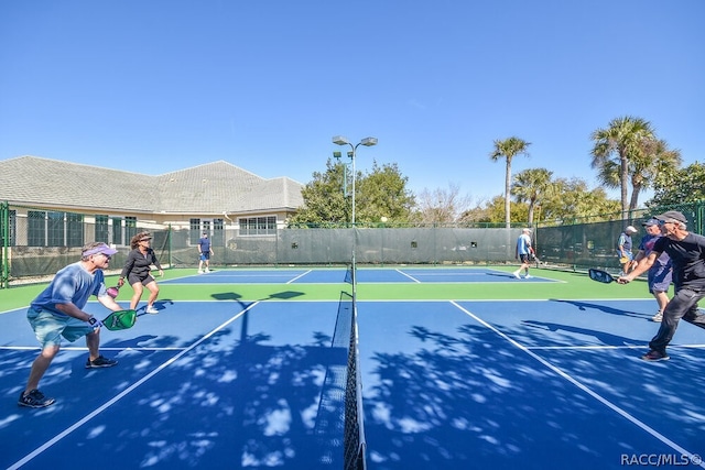 view of tennis court featuring basketball hoop