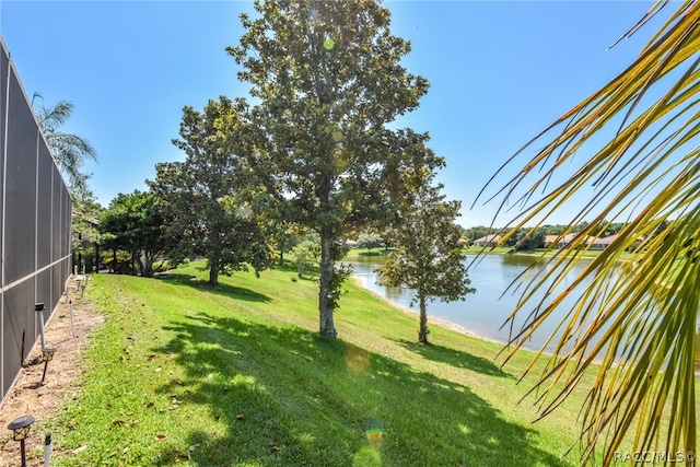 view of yard featuring a water view and glass enclosure