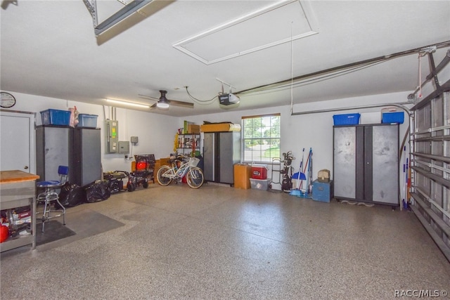 garage featuring electric panel, ceiling fan, and a garage door opener