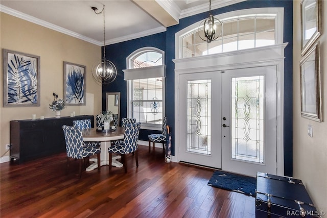 foyer featuring a chandelier, french doors, dark wood-type flooring, and ornamental molding