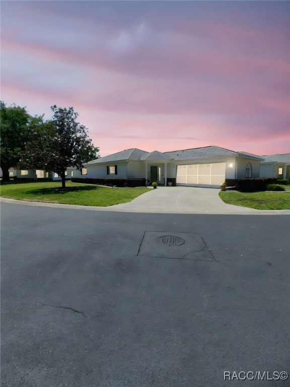 ranch-style home with a garage, a front lawn, and concrete driveway