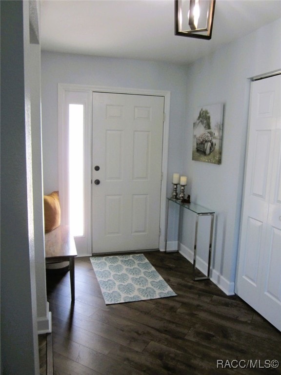 entryway featuring baseboards and dark wood finished floors