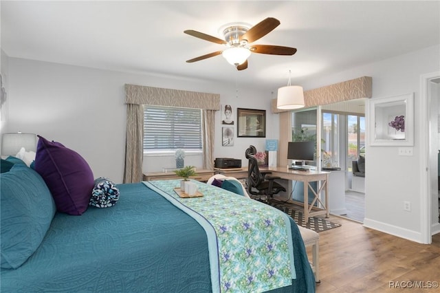 13618 SW 111th Cir, Dunnellon, FL 34432 - bedroom featuring multiple windows, wood finished floors, a desk, and baseboards