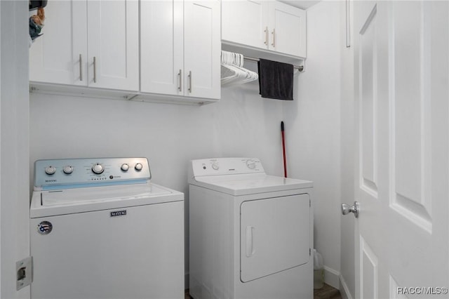 clothes washing area featuring independent washer and dryer and cabinet space