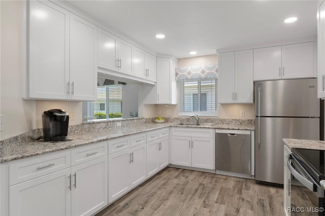 13618 SW 111th Cir, Dunnellon, FL 34432 - kitchen featuring stainless steel appliances, a sink, white cabinets, light wood-style flooring, and recessed lighting